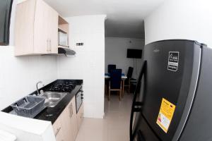 a kitchen with a black refrigerator and a table at Rodadero Apartment in Rodadero