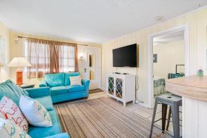 uma sala de estar com um sofá azul e uma televisão de ecrã plano em Seaward Villas 5 em Myrtle Beach