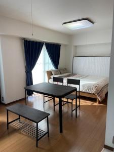 a room with a bed and two tables in it at G&R House 101 in Tokyo