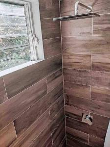 y baño con ducha y paredes de madera. en Vacation Home Blue Lotus- Gold Standard Certified en Caye Caulker