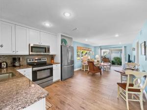 a kitchen with white cabinets and stainless steel appliances at Newly Fully Updated and Modern, Short Walk to BEACH in Siesta Key