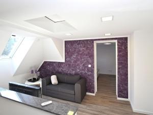 ein Wohnzimmer mit einem Sofa und einer lila Wand in der Unterkunft Holiday home in Elbingerode with garden in Höhlenort Rübeland