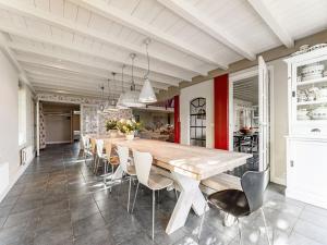 une salle à manger avec une grande table et des chaises en bois dans l'établissement Spacious and sustainable farmhouse in Heiloo with large garden, à Heiloo