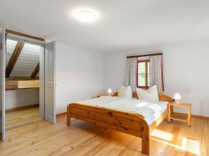 een witte slaapkamer met een bed en een trap bij Holiday home in the Upper Palatinate Forest in Neunburg vorm Wald