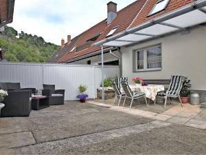 eine Terrasse mit einem Tisch, Stühlen und einem Zaun in der Unterkunft Holiday home in Elbingerode with garden in Höhlenort Rübeland