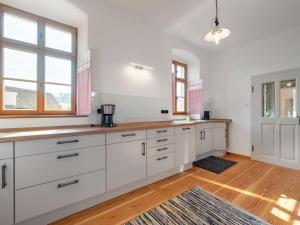 cocina con armarios y ventanas blancos y suelo de madera en Holiday home in the Upper Palatinate Forest en Neunburg vorm Wald