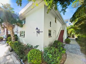 una casa blanca con una palmera delante de ella en Walk to Beach, Updated Condo, Private Patio and Grill, en Siesta Key