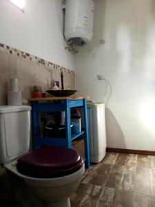 La salle de bains est pourvue de toilettes et d'une table bleue. dans l'établissement Viudita del Diablo, à Punta del Diablo