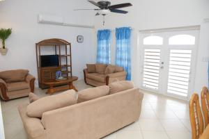 a living room with a couch and chairs and a tv at Breezee in Long Path