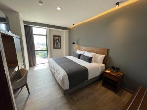 ein Schlafzimmer mit einem Bett, einem Stuhl und einem Fenster in der Unterkunft Gumont Guadalajara López Mateos - Minerva in Guadalajara