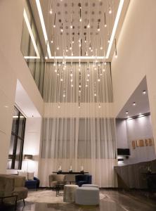 a lobby with a large chandelier in a building at Gumont Guadalajara López Mateos - Minerva in Guadalajara