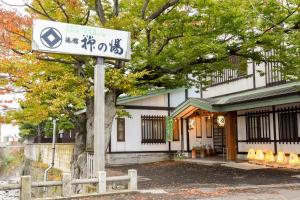 una señal en un poste frente a un edificio en Yanagi No Yu, en Aomori