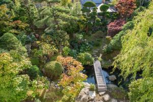 青森的住宿－柳湯民宿，一座花园的模型,一座花园上设有一座河上的木桥