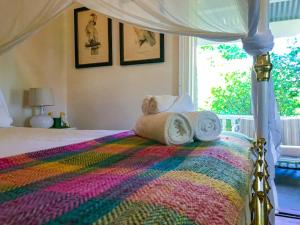 a bed with a colorful blanket and towels on it at Arcadia House in Byron Bay