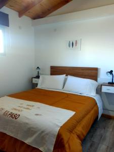 a bedroom with a large bed with a wooden headboard at Encanto Patagónico in El Bolsón
