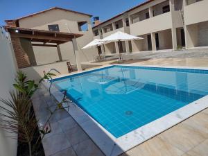 a large blue swimming pool next to a building at Residencial Secret Point in Praia do Frances