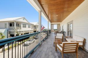 a balcony with chairs and tables on a house at Hotel Whiskey in Pass Christian in Pass Christian