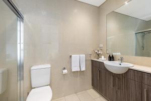a bathroom with a toilet and a sink and a mirror at Seaside Luxury Accommodation in the Heart of Rye in Rye