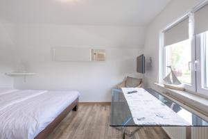 a bedroom with a bed and a glass table at DeKo in Husum