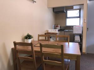 a kitchen with a wooden table and four chairs at Alpine Chalets Hakuba in Hakuba