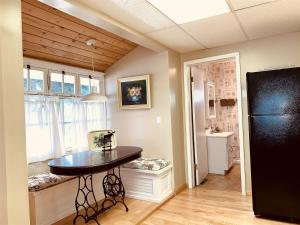 een keuken met een tafel en een zwarte koelkast bij Red Lodge Town Cottage in Red Lodge