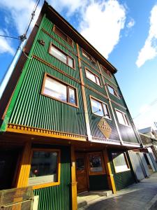 ein Gebäude mit einem grünen und weißen Gebäude in der Unterkunft YAGHAN HOSTEL in Ushuaia