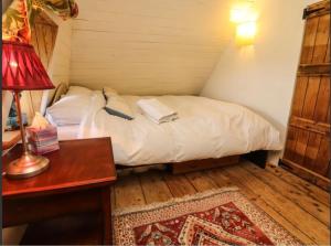 a small bedroom with a bed and a desk with a lamp at New Thatch Farm, knocklong, Limerick in Cross of the Tree