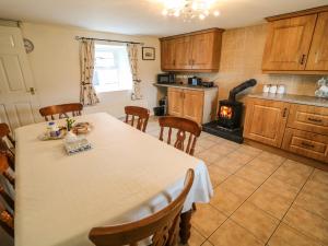 kuchnia ze stołem, krzesłami i kuchenką w obiekcie Shaws Hill Farmhouse w mieście Ballymena