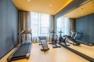 a gym with several tread machines and a mirror at Atour Hotel Hangzhou Future Technology City Haichuang Park in Hangzhou