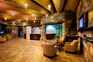 a lobby with a stone wall and a table and chairs at Bitez Risa Hotel in Bitez