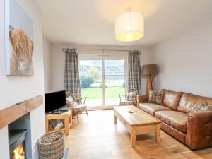 a living room with a couch and a fireplace at Holly Cottage in Glencoe