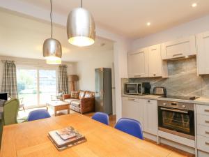 a kitchen and dining room with a table and chairs at Holly Cottage in Glencoe