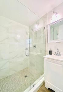 a white bathroom with a shower and a sink at Cute Tiny House w Private Plunge Pool near Beach in Delray Beach