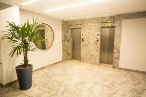 un corridoio con una pianta in vaso e uno specchio di Regency Copacabana Hotel a Rio de Janeiro