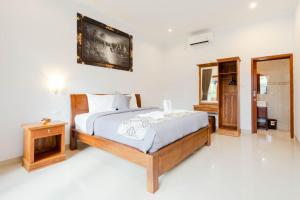 a bedroom with a large bed and a mirror at Prama Beach Canggu by The Loka in Canggu
