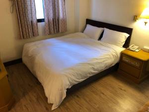 Postel nebo postele na pokoji v ubytování 金麗麗大飯店