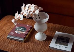 stół z wazonem z kwiatami i książką w obiekcie The Rooms Milton w mieście Milton