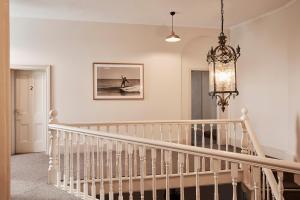 Una escalera blanca con una lámpara de araña en una casa en The Rooms Milton, en Milton