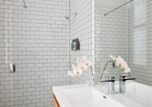 a white bathroom with a sink and a mirror at The Rooms Milton in Milton