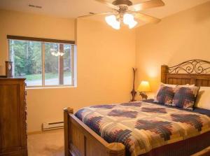 1 dormitorio con 1 cama, ventilador de techo y ventana en NEW HOT TUB! Secluded, tucked away cabin, en Fairplay