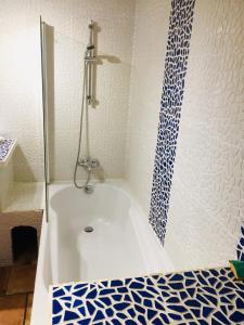 a white bath tub with a blue and white pattern at Rez de jardin de chalet bois , calme et verdure ! in Saint-Martin-Vésubie