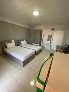 um quarto de hotel com duas camas e uma mesa em Burapha Bangsaen Garden Apartment em Bangsaen