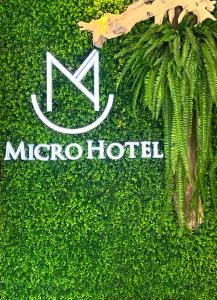 una señal para un micro hotel en un seto verde en Fengjia Micro Hotel, en Taichung