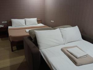 a hotel room with two beds with white pillows at AB Star Suites in General Santos