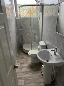 a bathroom with a shower and a toilet and a sink at NIRO's Hotel in Blackpool