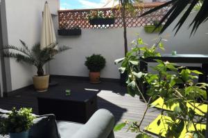 a patio with potted plants and an umbrella at La Perle Marine 3 in Le Grau-du-Roi