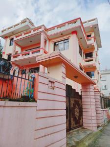 une maison rose avec une porte devant elle dans l'établissement Monkey Bunky-3Monkeys Backpacker's Hostel, à Katmandou