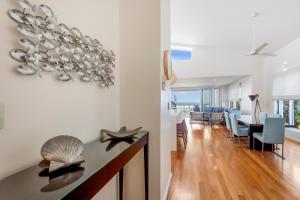 a living room and dining room with a dining table at Costa del Sol - Beachfront Lennox Head in Lennox Head