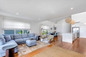a living room with a blue couch and a table at Costa del Sol - Beachfront Lennox Head in Lennox Head