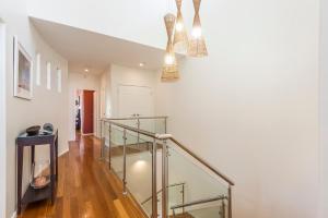 a staircase with glass railings in a house at Costa del Sol - Beachfront Lennox Head in Lennox Head +31 photos